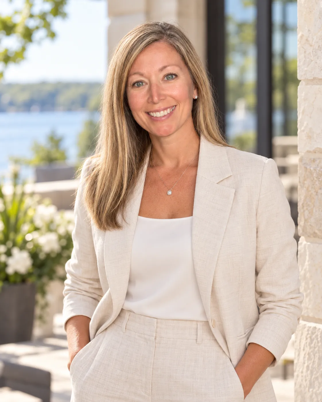 Amie Oren standing beside a stone wall with a lake behind her